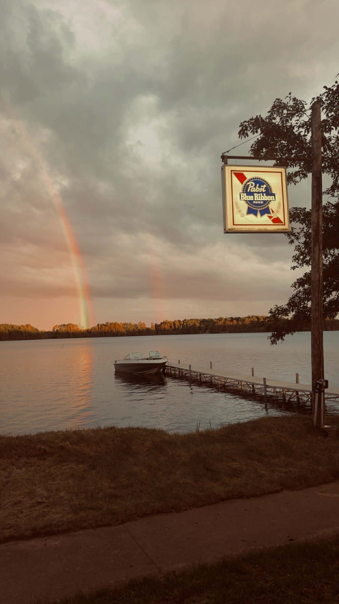 Rainbow over the lake with a vintage lakeside sign