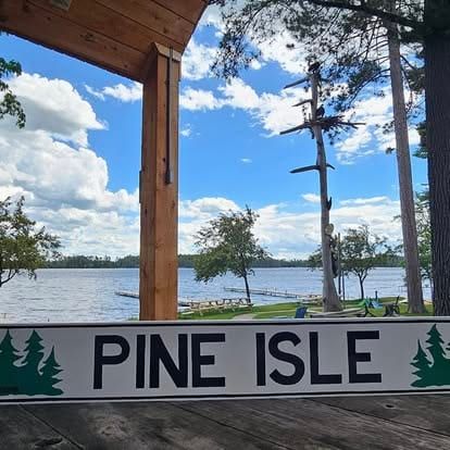 Pine Isle sign on the deck overlooking the lake